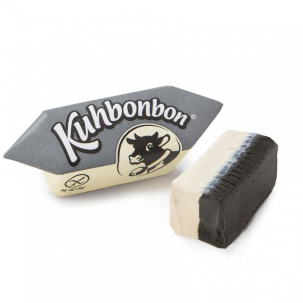 Two pieces of two-layered soft cream licorice caramels from the German candy manufacturer Kuhbonbon, one individually wrapped