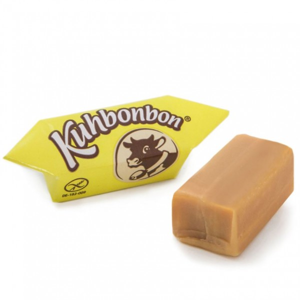 Two pieces of soft caramels with eggnog flavor from the German candy manufacturer Kuhbonbon, one individually wrapped
