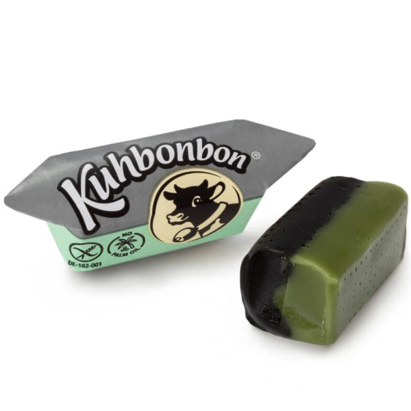 Two pieces of two-layered soft mint licorice caramels from the German candy manufacturer Kuhbonbon, one individually wrapped
